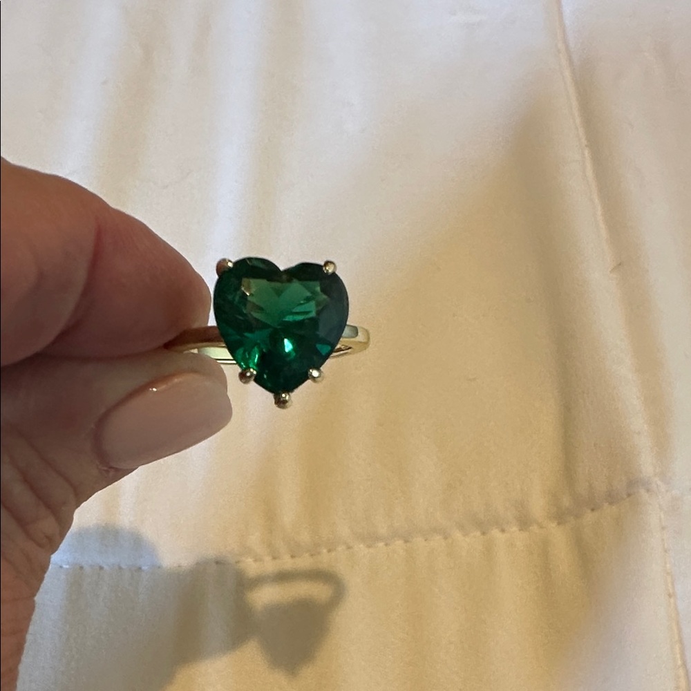 Melinda Maria emerald colored stone in a heart shape.